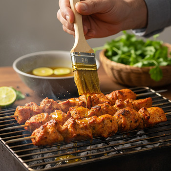 Basting tikka with mustard oil and lime