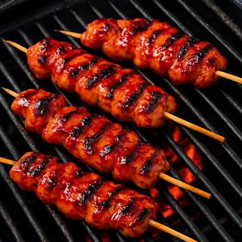 Chicken skewers lacquered with chili-tamarind glaze on the grill