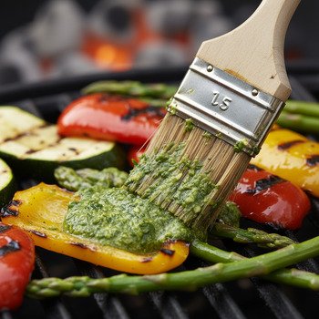 Brush painting green chutney on grilled veg